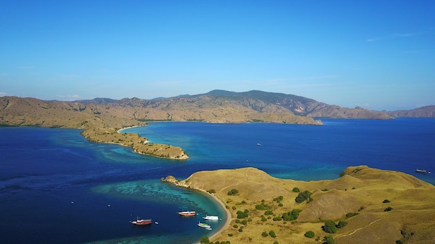 Belle plage bleue et ciel bleu entouré de collines incroyables avec peu de bateau