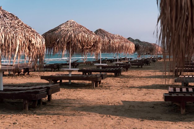 Belle plage avec chaises longues au coucher du soleil