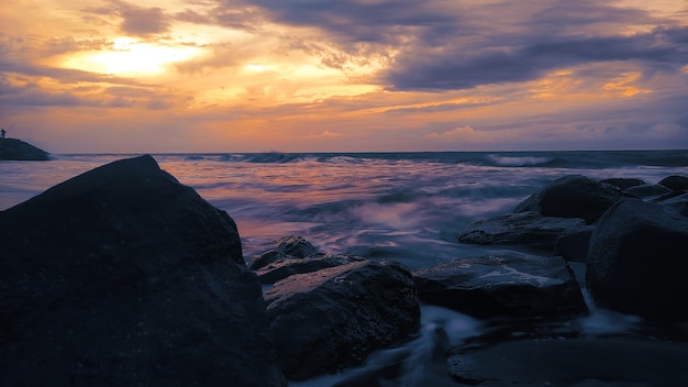 Belle plage de coucher de soleil avec des rochers