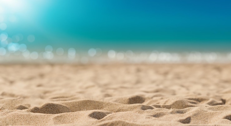 Photo belle plage avec du sable et de la mer en arrière-plan hors focus pendant la journée en haute résolution et la netteté