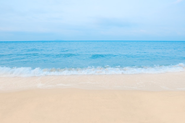 Belle plage en été, mer bleue avec du sable blanc.