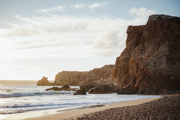 Belle plage avec des falaises escarpées pendant l'heure d'or Algarve Portugal