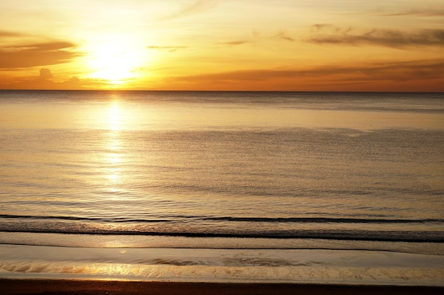 La belle plage avec le lever du soleil tôt le matin