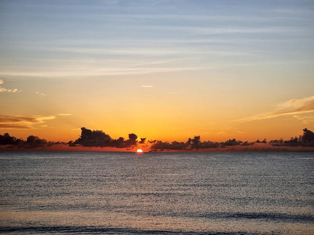 La belle plage avec le lever du soleil tôt le matin