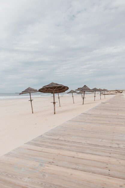 Belle plage avec parasols et passerelle en bois au bord de l'océan