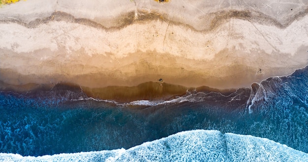 Belle plage de sable et océan avec des vagues vues d'en haut