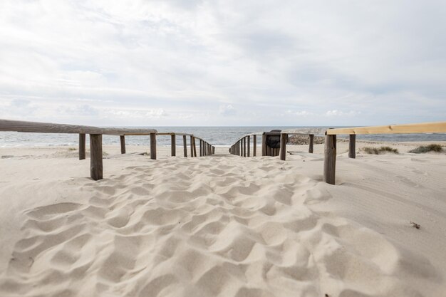 Belle plage de sable et passerelle en bois au bord de l'océan