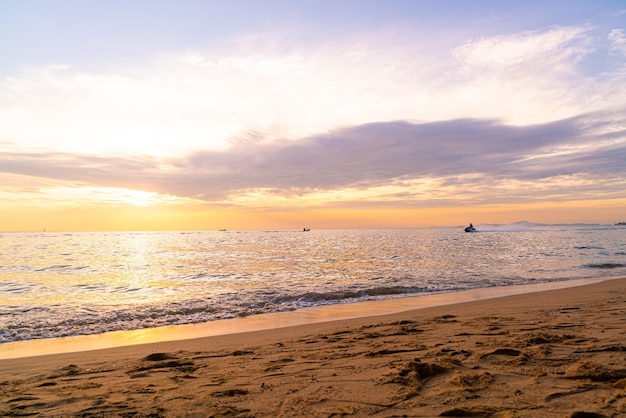 belle plage tropicale et mer avec ciel crépusculaire au coucher du soleil