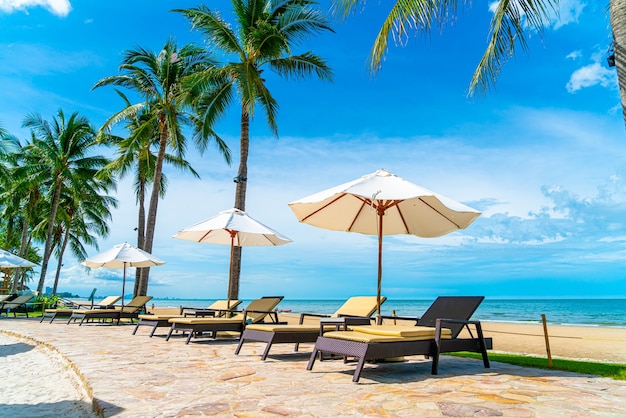 Belle plage tropicale et mer avec parasol et chaise autour de la piscine dans la station de l'hôtel pour les voyages et les vacances