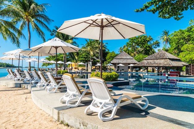 Belle plage tropicale et la mer avec parasol et chaise autour de la piscine