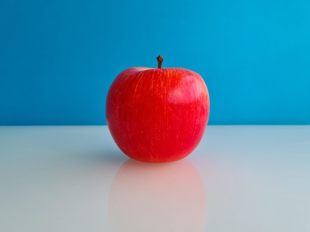 Belle pomme mûre rouge sur fond bleu