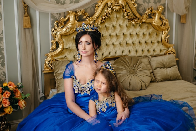 Belle princesse mère et fille dans une couronne en or