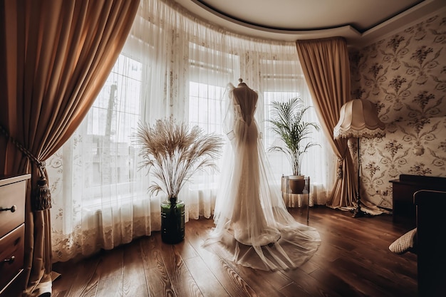 Belle robe de mariée accrochée dans la chambre femme se prépare avant la cérémonie