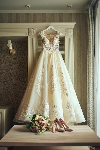 Belle robe de mariée accrochée dans la chambre femme se prépare avant la cérémonie