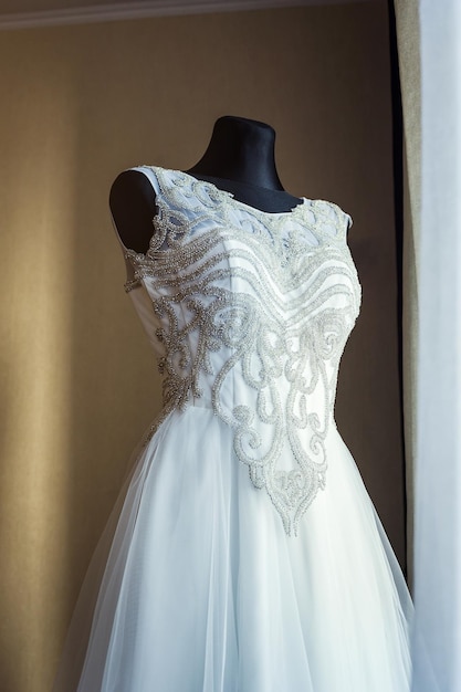 Belle robe de mariée accrochée dans la chambre femme se prépare avant la cérémonie