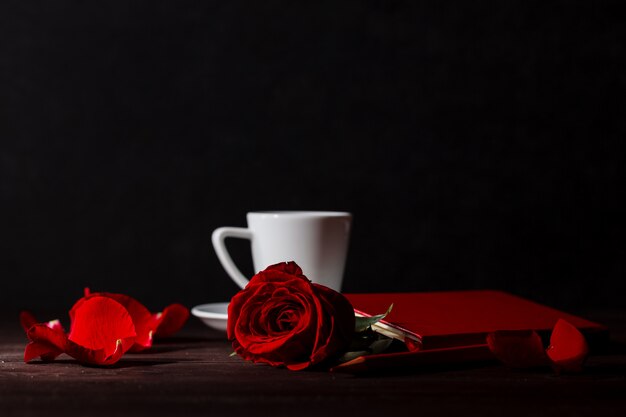 belle rose rouge sur fond noir avec du café