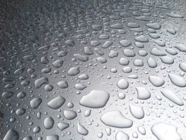 Belle rosée de pluie sur le toit de la voiture.