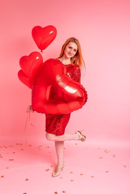 Belle rousse avec ballon coeur rouge posant. Concept de la Saint-Valentin heureuse