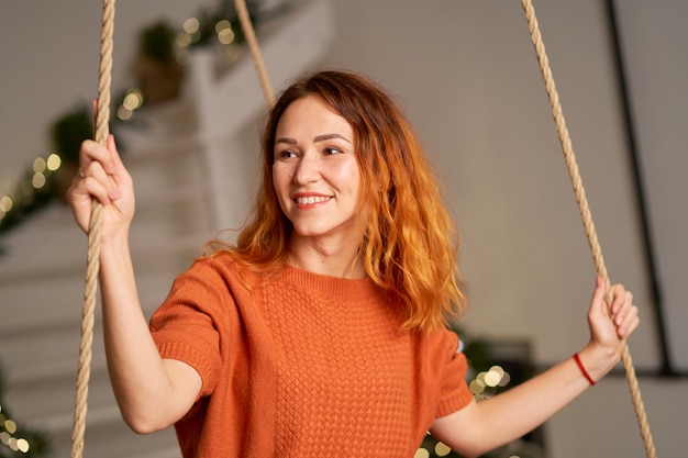 Une belle rousse se balance dans sa chambre le soir de Noël.