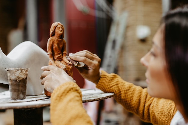 Belle sculptrice professionnelle de femme d'âge moyen travaillant sur une magnifique sculpture.