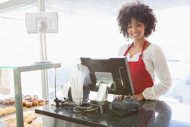 Belle serveuse qui pose derrière le comptoir