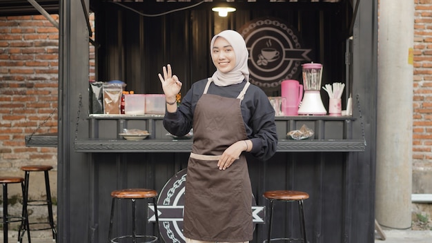 Belle serveuse souriante prête à ouvrir le conteneur de stand de café