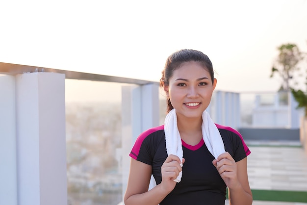 Belle sportive asiatique en bonne santé portant un survêtement avec une serviette