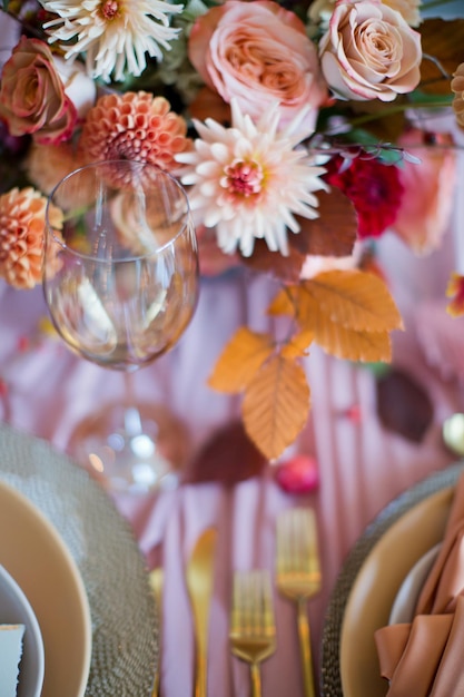 Belle table avec des fleurs d'automne des serviettes orange et roses et des bougies allumées Concept de mariage d'automne