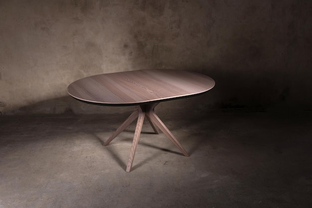 Une belle table pliante en bois brun sur fond de béton beige