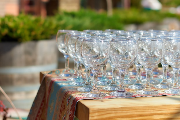 Belle table de vacances verres de vin en verre deux rangées de verres sur une table avec une nappe blanche sur de hautes jambes placées un verre de vin sur une table de fête