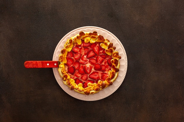 Belle tarte aux fraises sur une assiette avec une spatule