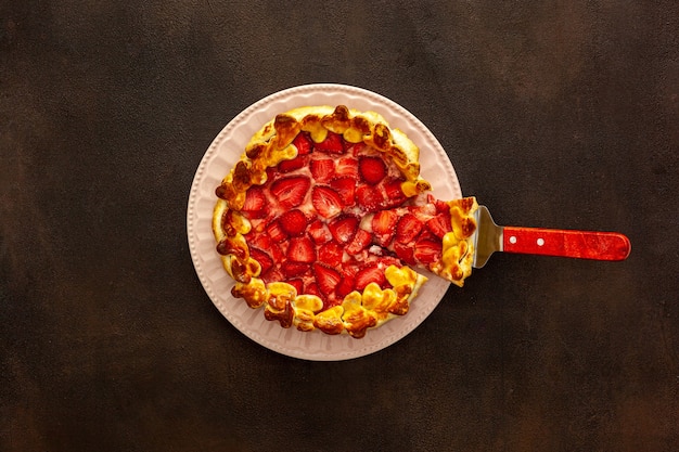Belle tarte aux fraises sur une assiette avec une spatule