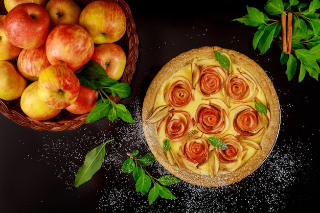 Belle tarte aux pommes maison sur fond noir avec des pommes fraîches Vue de dessus