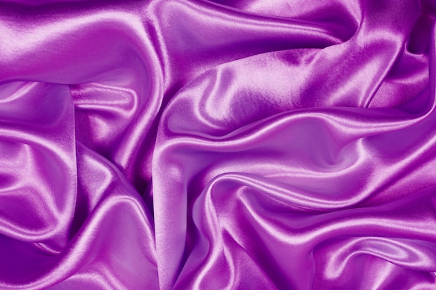 La belle texture de tissu de luxe en satin violet peut servir de fond de mariage, de tissu