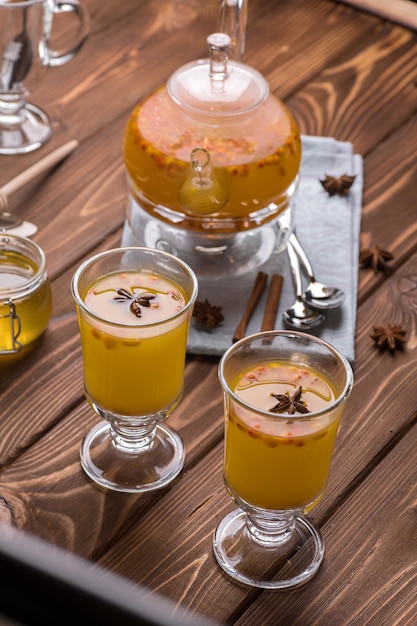 Belle théière en verre avec thé à l'argousier orange.