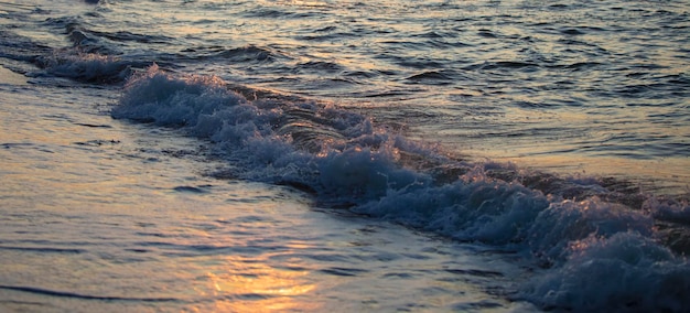 Photo belle vague d'écume dans la mer du soir