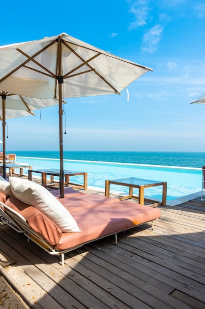 belle et vide chaise et parasol avec piscine et plage de la mer