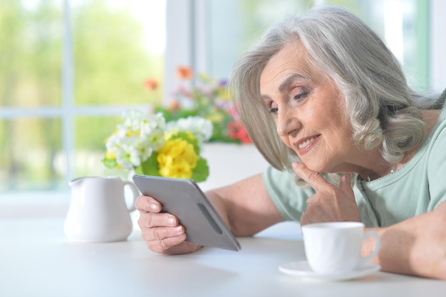 Belle vieille femme avec une tablette