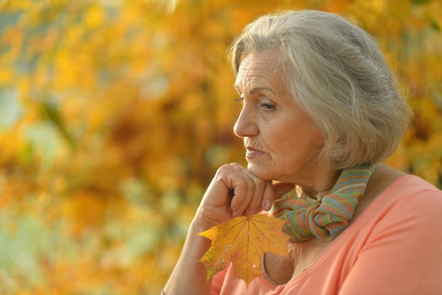 Belle vieille femme triste sur le fond d'automne