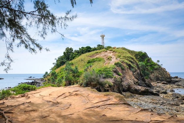 Photo belle vue sur une colline rocheuse avec un phare blanc