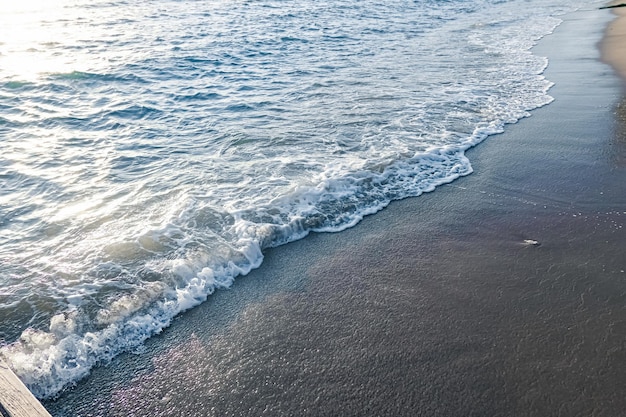 Belle vue sur la côte des vagues de la mer ou de l'océan depuis la plage de sable tropical voyage de vacances d'été et destination de vacances