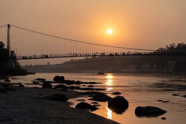 Belle vue sur l'eau du Gange et le pont Ram Jhula au coucher du soleil. Rishikesh, Inde