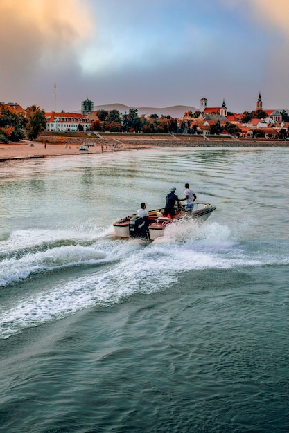 Belle vue sur les gens s'amusant sur un bateau à moteur à la plage - tir vertical