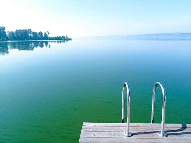 Belle vue sur le lac vert fleuri avec une jetée