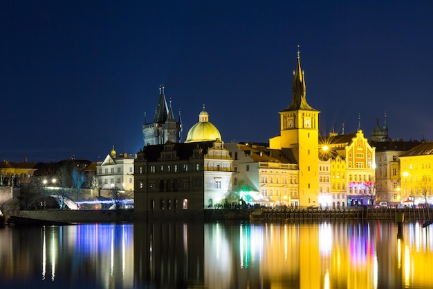 Belle vue nocturne sur le pont Charles, la tour du pont de la vieille ville et le vieux château d'eau, le quai Smetana et le musée de la bière de Prague en République tchèque.