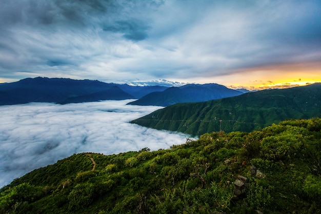 Photo belle vue sur le paysage au-dessus des nuages et du soleil chaud apparaissant à l'aube rupac pérou