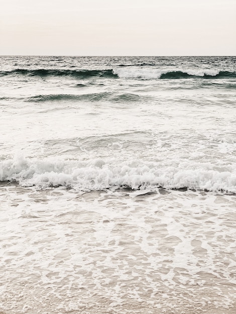 Belle vue sur la plage tropicale avec sable blanc, mer beige avec vagues et ciel clair sur Phuket