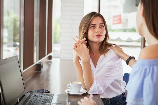 Belles amis en dégustant un café au café ensemble