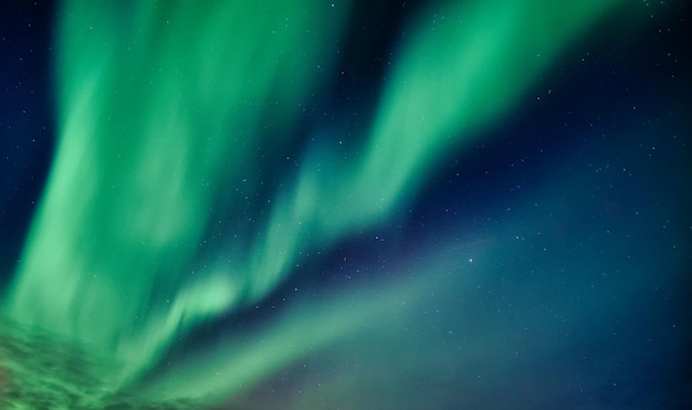 Belles aurores boréales et étoiles brillantes dans le ciel nocturne sur le cercle arctique