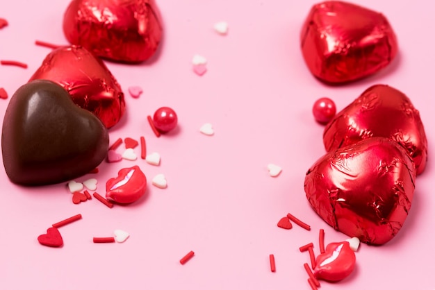 Belles bonbons coeurs au chocolat rouge sur fond rose Saint Valentin